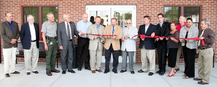 Bill Schwartz/Gettysburg Times - CEREMONY - Taking part in the ribbon-cutting to mark the opening of the Gettysburg Transit Center on Carlisle Street Thursday afternoon are, from left: Keith Martin, York Adams Transit Authority (YATA) board member; George Hime, YATA board member; Bob Kirby, Gettysburg National Military Park superintendent; Ray Rosen, YATA board chairman; Robert Garrett, PennDOT representative; Sen. Rich Alloway; State Rep. Dan Moul; Gettysburg Mayor Bill Troxell; Adams County